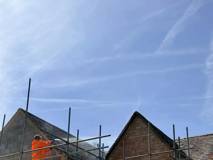 Operative working safely from scaffolding on a roof