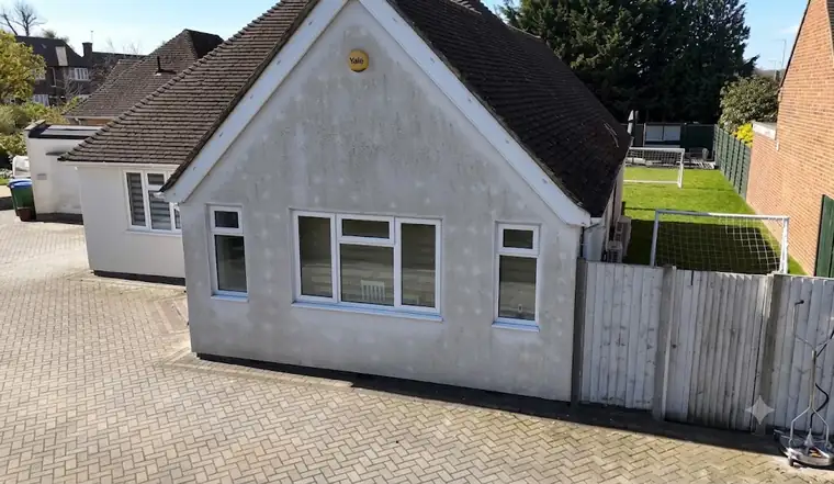 Grey, algae-spotted render on a Hertfordshire bungalow before soft washing